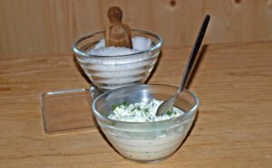 Das Salzen und beimengen von Kräutern im Frischkäse Rezept.